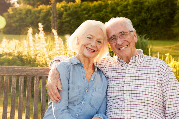 Smiling elderly couple sitting outdoors representing healthy retirement